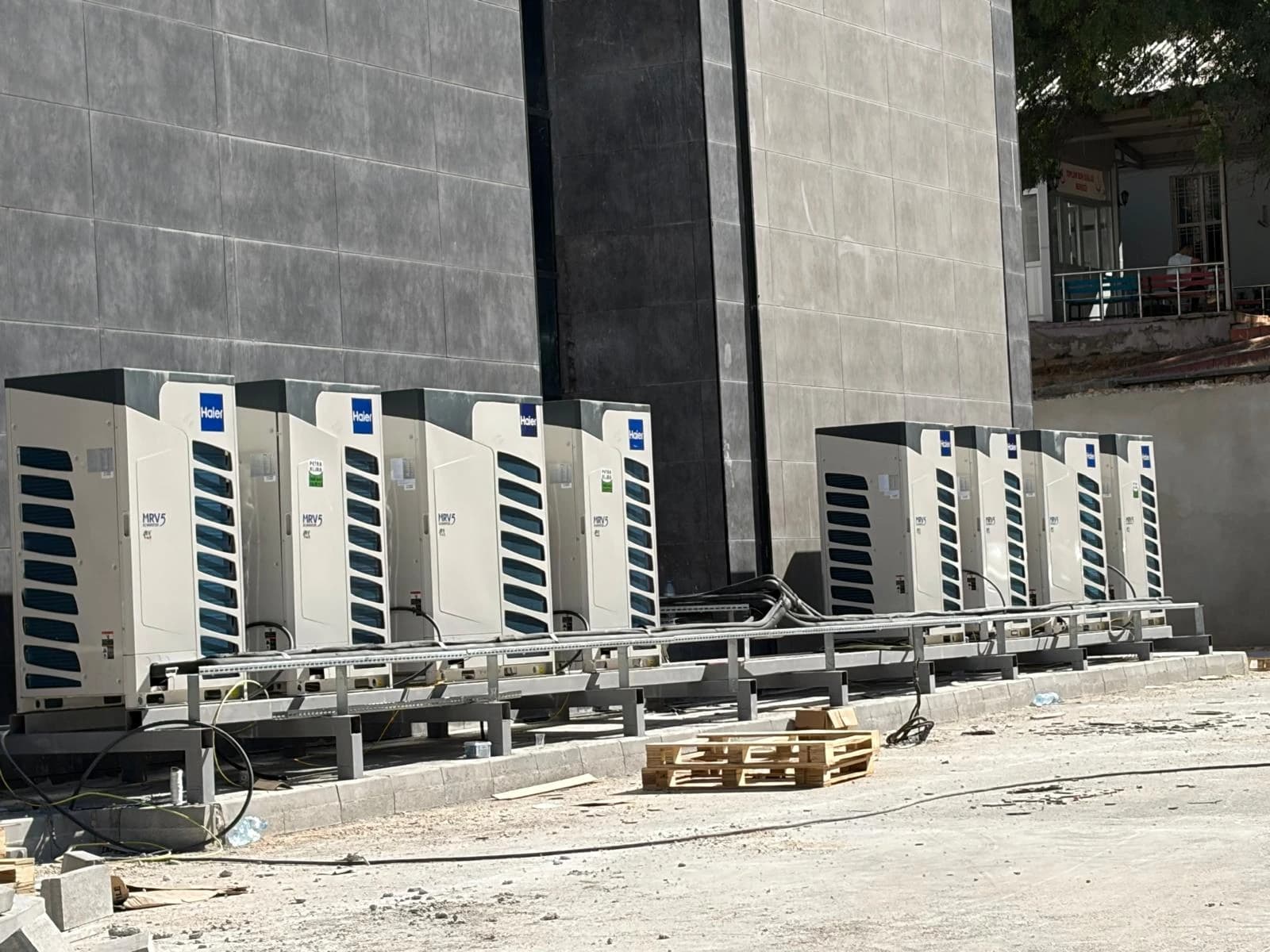 Çok katlı ticari bina cephesinde Haier MRV5 dış ünite sırası.